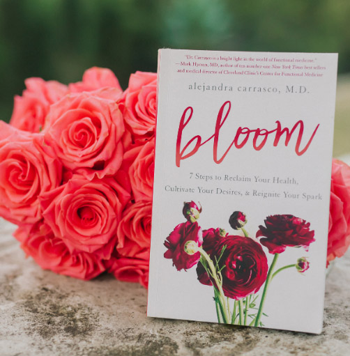 Bloom book cover in front of flowers